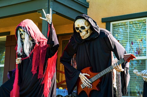 Ghostly skeleton singers in neighborhood Halloween yard decoration in celebration of traditional Hal...