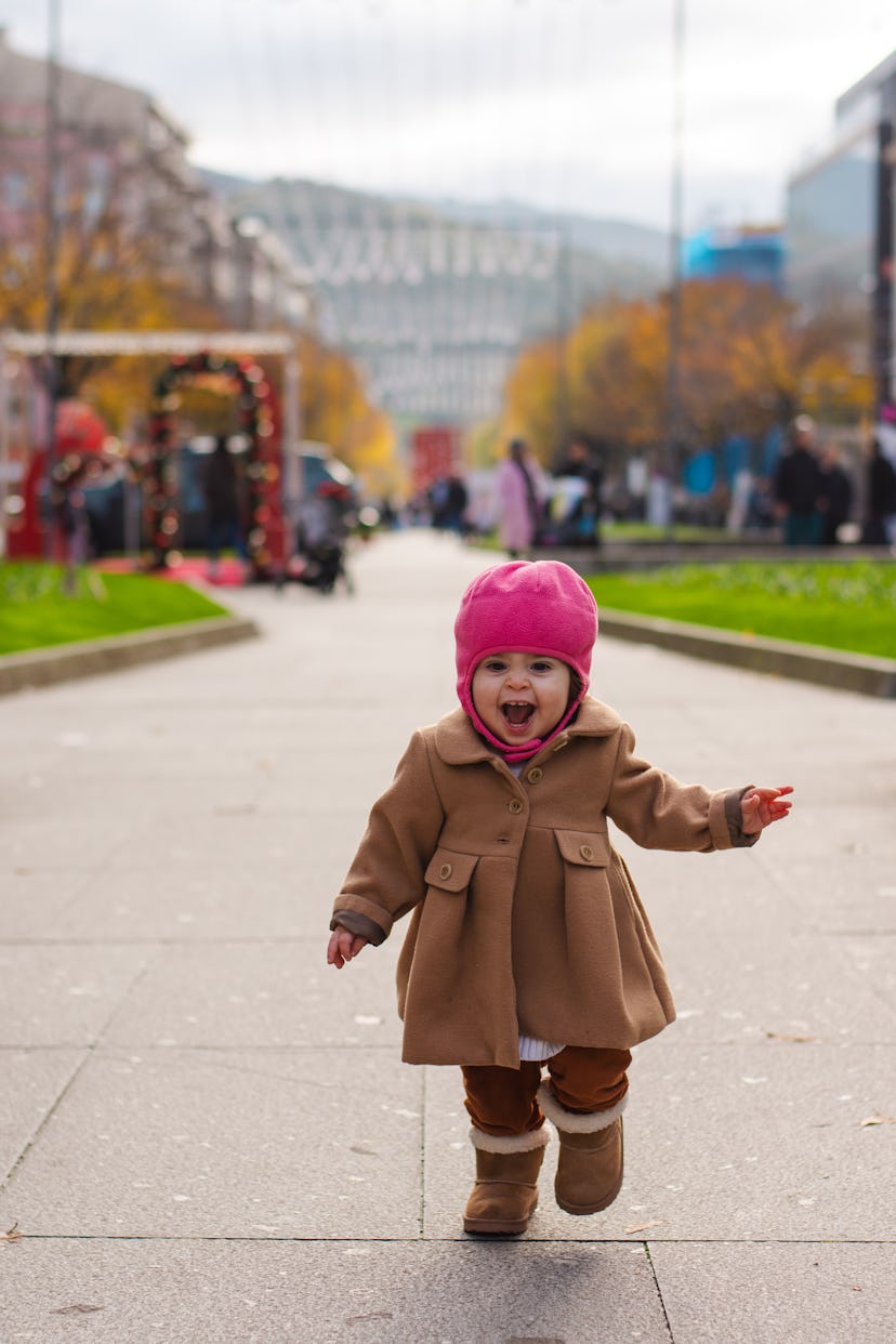 Happy little girl walking in the street