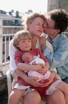 Owen Franken kisses his wife, Annemiek, as she sits with their son, Tunui, and their newborn daughte...