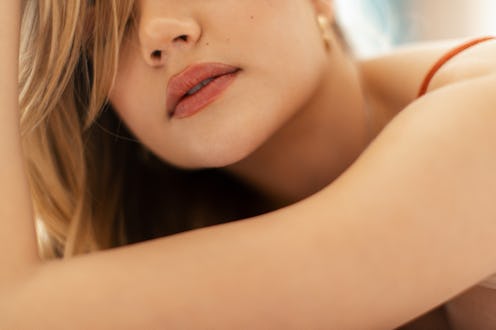 Attractive young blond woman lying on bed, relaxing.