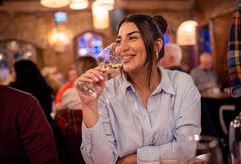 Young smiling woman enjoying a lovely night at the restaurant