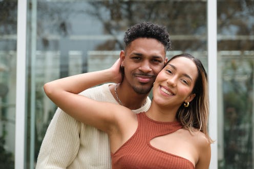 Happy young multi-ethnic couple embracing and smiling at camera