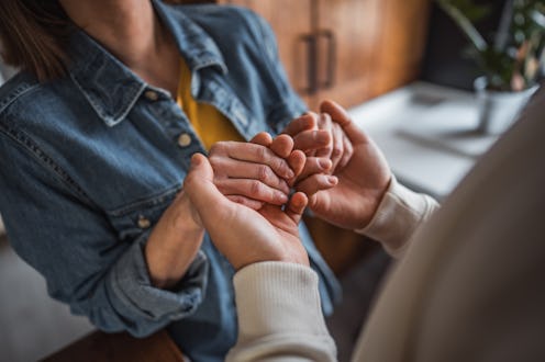 A couple holding hands tightly, symbolizing their deep connection and affection. With their fingers ...
