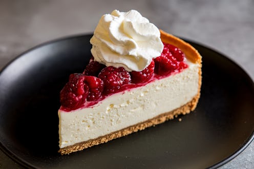 A photo of a slice of cheesecake on a black background