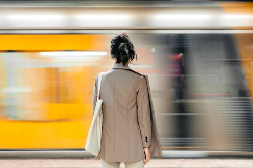 Rear-view of a beautiful young Japanese Asian businesswoman standing on the street in Sydney in Aust...