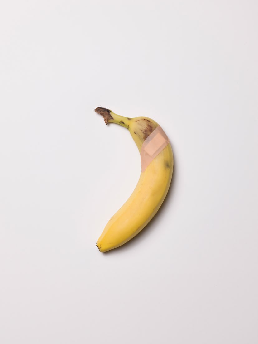 high angle view of High angle view of bruised banana with a plaster against a white background
