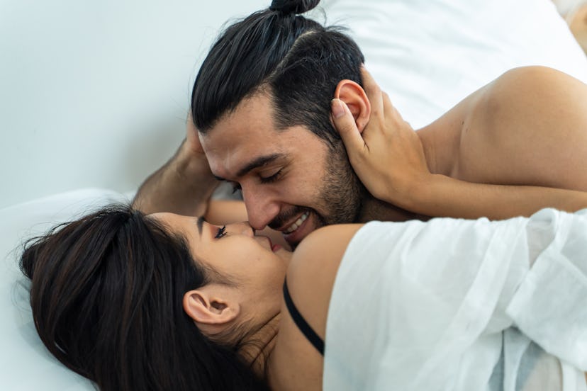 This couple is enjoying a good kiss in bed