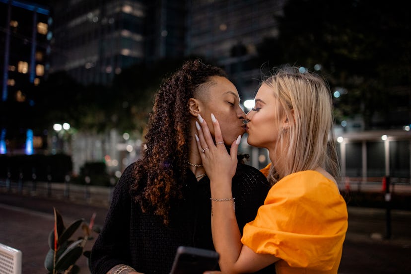 This couple is kissing in a city
