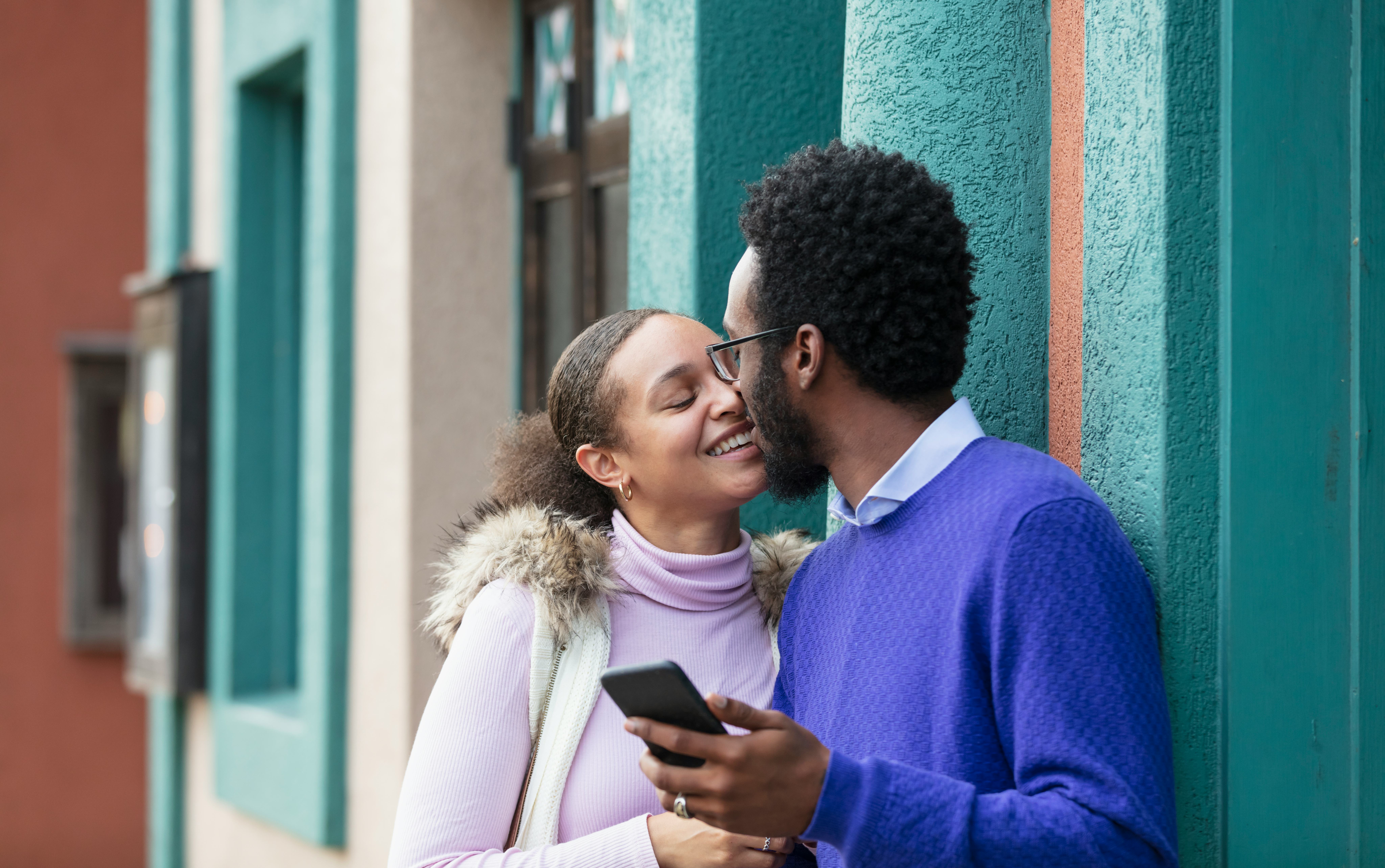 This couple is kissing with their eyes closed