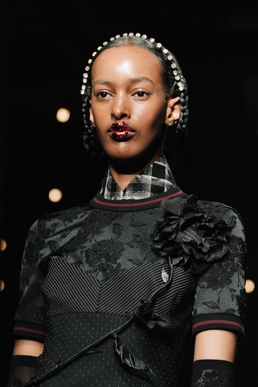 A model with glitter lips walks the runway at the Antonio Marras fashion show during the Milan Fashi…