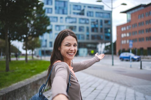 Young woman taking selfie and showing malmo city in sweden