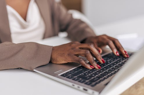 Close-up of a woman's hand typing on a keyboard