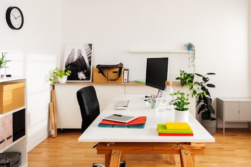 Modern and tidy home office space with computer, tablet, and colorful stationery, promoting producti...
