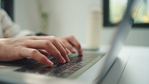 Asian young man use laptop while wearing headphones.