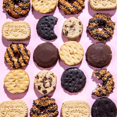 An array of Girl Scouts Cookies on a pink background.