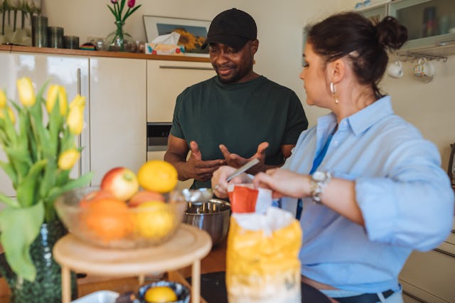 Black man in baseball cap telling news to wife, gesturing emotional moments, after work. Woman in bl...
