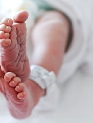 Newborn baby boy at hospital with identity tag on feet, close up