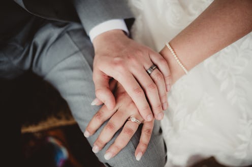 Man and woman with hands showing off engagement ring and wedding band
