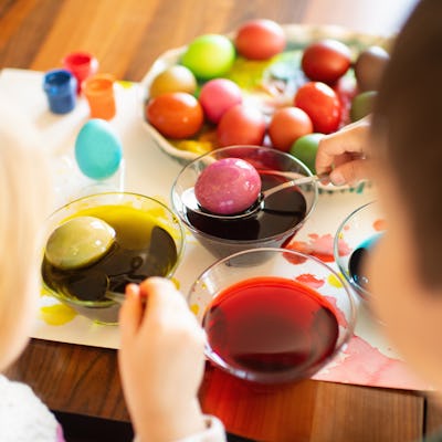 Boy and girl painting Easter eggs at home