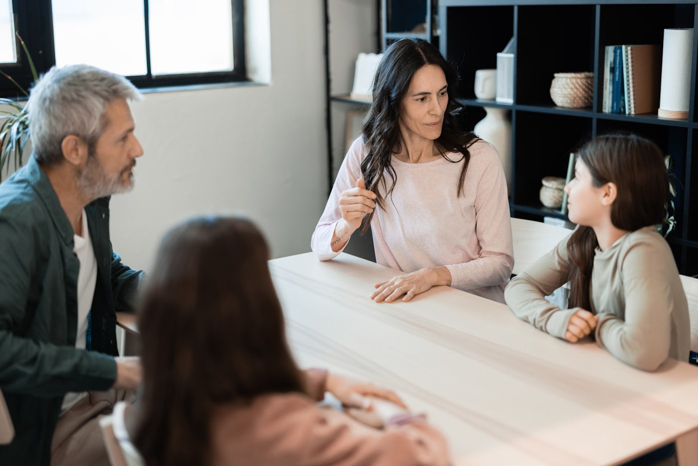 Woman and her husband having a serious conversation with their two teenage daughters