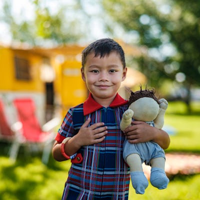 Boy holding a baby doll. A Reddit thread answered the question, do little boys want to be dads when they grow up?