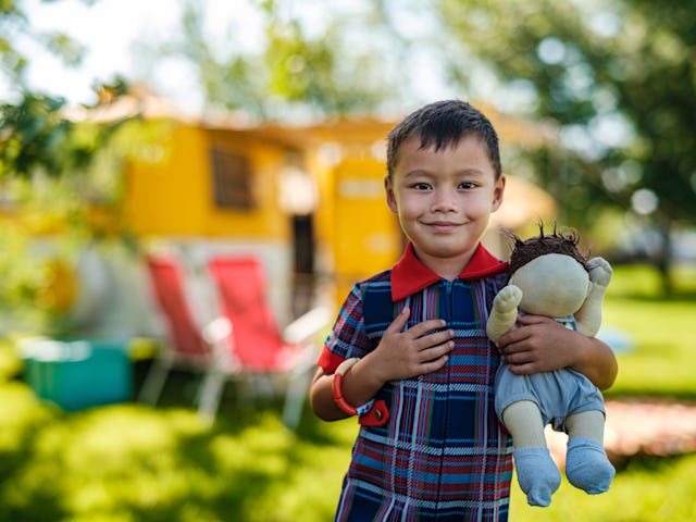 Boy holding a baby doll. A Reddit thread answered the question, do little boys want to be dads when ...