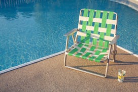 Retro summer background, vintage summer background. Empty outdoor chair next to swimming pool during...