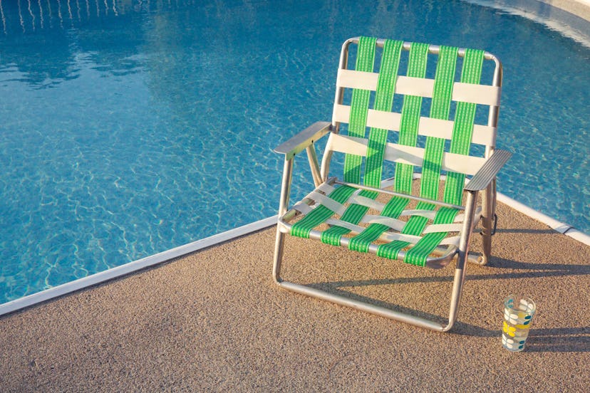 Retro summer background, vintage summer background. Empty outdoor chair next to swimming pool during...