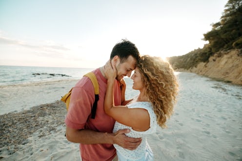 Young couple looking each other on the beach at late sunset