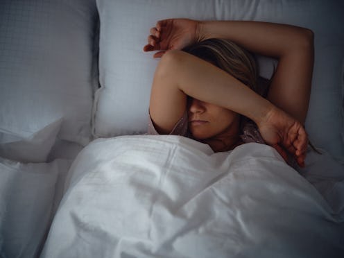 Above view of a woman taking a nap in her bed at night. Photographed in medium format.