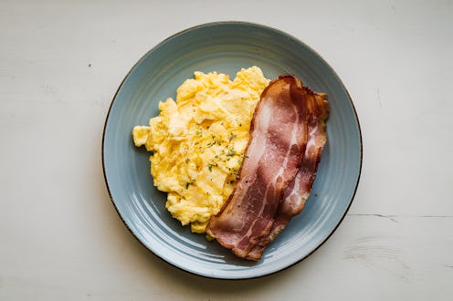 a scrambled egg with sliced bacon on a plate