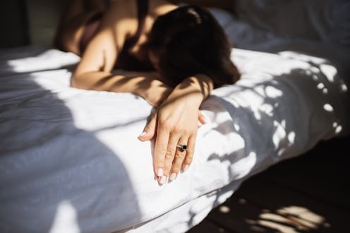 First morning as wife: Stunning mature woman with long brown hair in chic brown underwear lies in be...