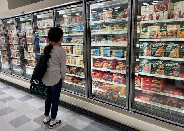 A customer shops in the ready to eat meals aisle of a grocery store.