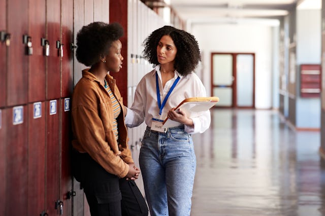 Teacher talking with tensed teenage girl. School psychologists and counselors will likely be cut fro...