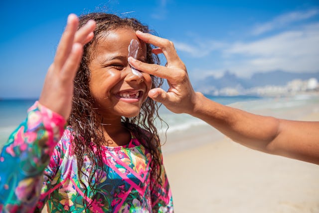 The caring father prepares his beautiful daughter for surfing