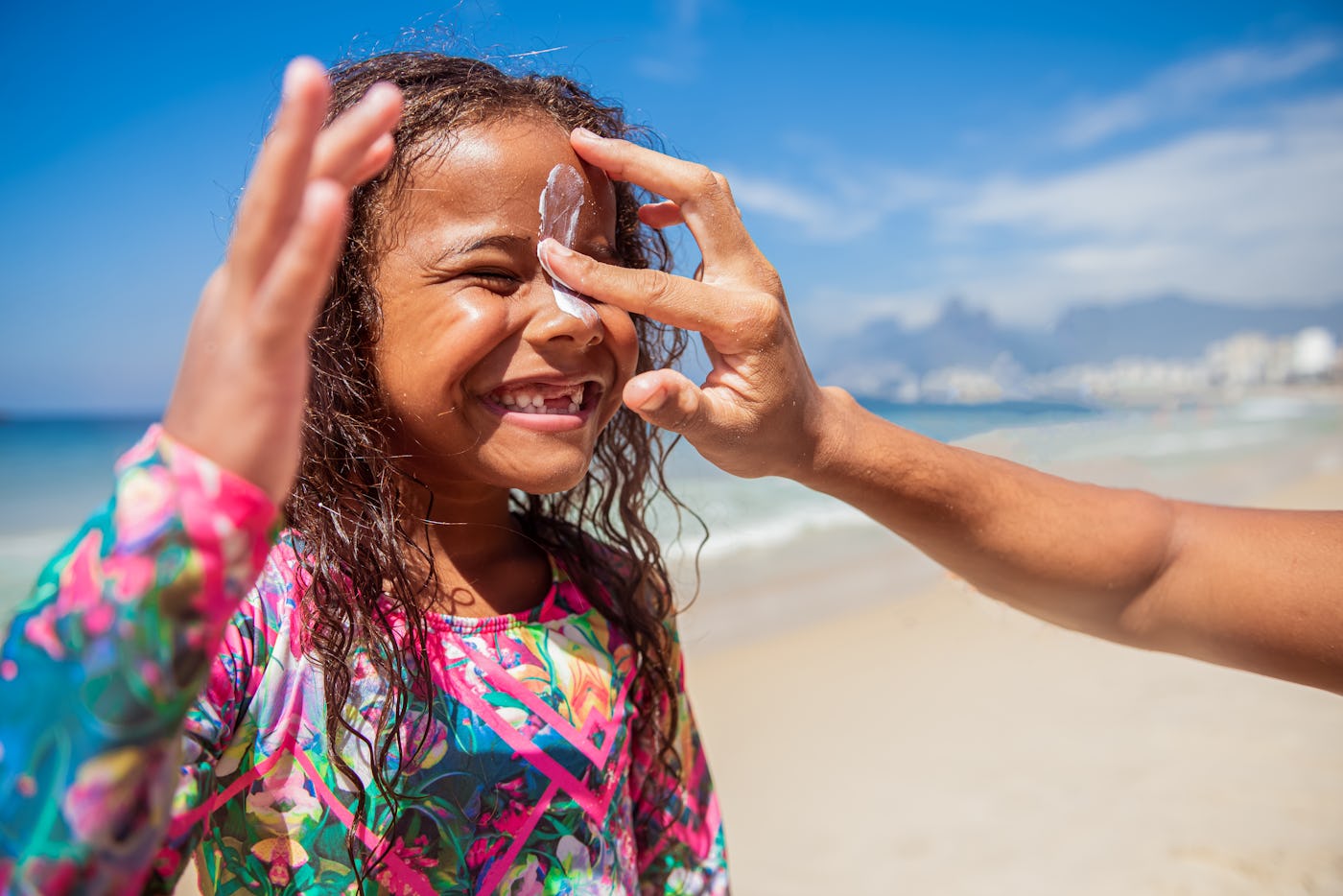 The caring father prepares his beautiful daughter for surfing