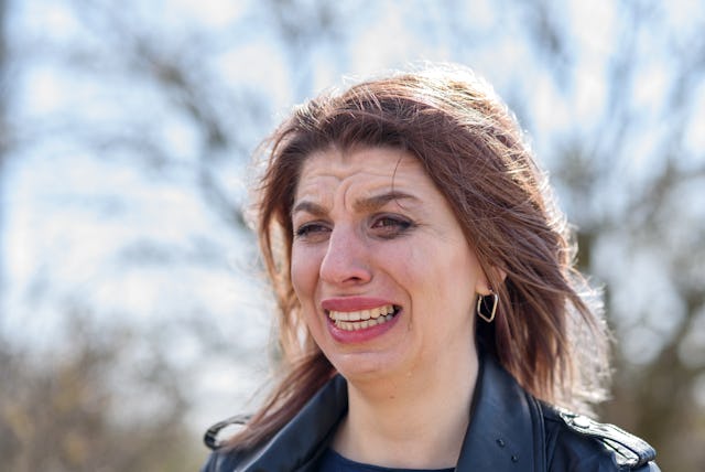 Crying woman face close up, tears, flowed mascara. outdoors
