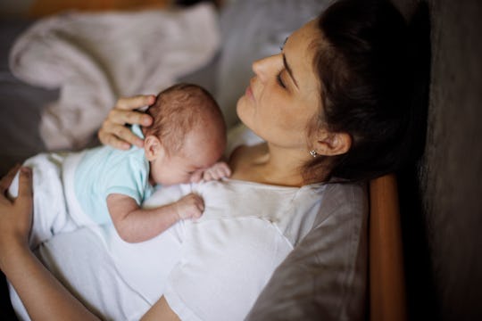 https://imgix.bustle.com/uploads/getty/2025/5/27/cc4b0ccf/exhausted-mother-holding-her.jpg?w=540&h=360&fit=crop&crop=faces