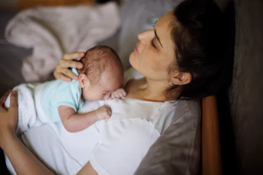 https://imgix.bustle.com/uploads/getty/2025/5/27/cc4b0ccf/exhausted-mother-holding-her.jpg?w=540&h=360&fit=crop&crop=faces