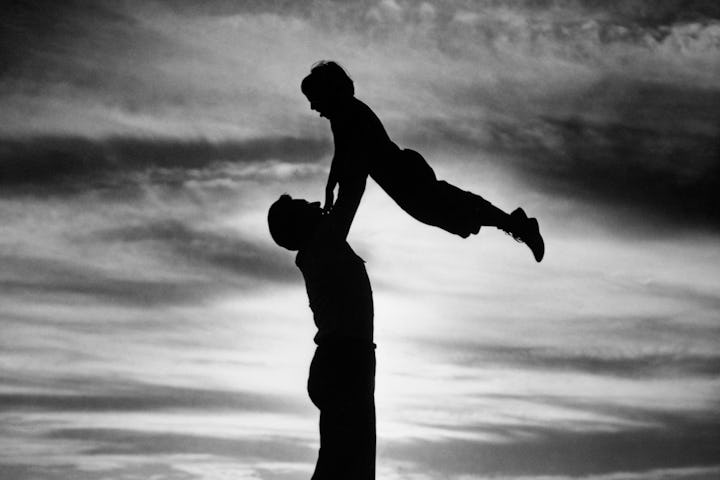 1940s 1950s ANONYMOUS SILHOUETTED MAN FATHER LIFTING CHILD SON IN AIR ON SHORE AT DUSK (Photo by H....