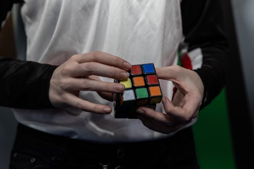 MILAN, ITALY - NOVEMBER 18: A young woman handles a Rubik's Cube mechanical puzzle during the "Entra...