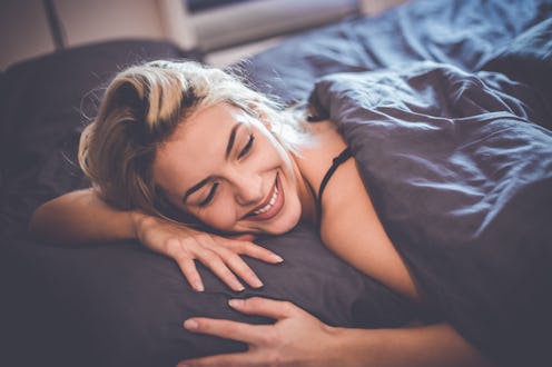 Young attractive blonde girl lying in bed in the bedroom