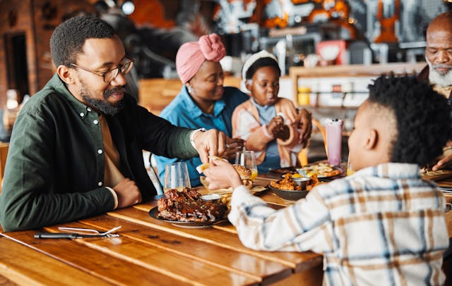 Black family, restaurant and food share with dad and child together with bonding, eating and care. L...