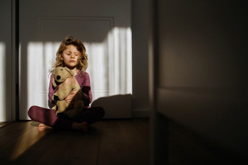 Portrait of young girl hugging her teddy bear plush toy.