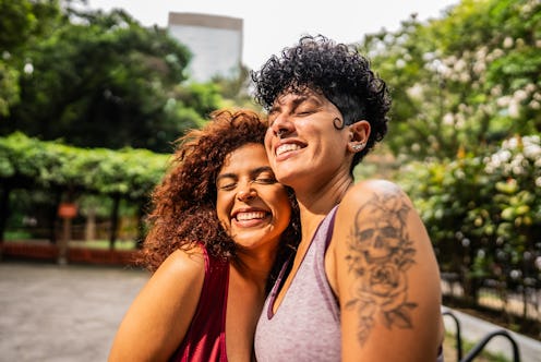 Friends women embraced on public park