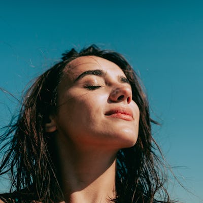 Self-portrait photo of a young woman at the beach.