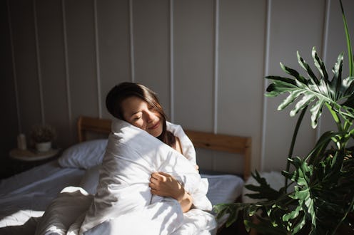 Morning serenity: With favorite blanket enveloping in soothing embrace, contented mature woman with ...