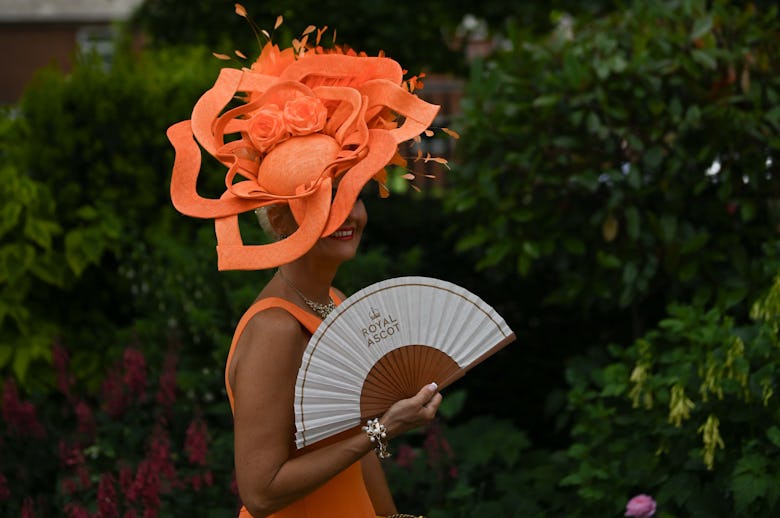 Guests, wearing colorful dresses and hats, attend the first day of the traditional Royal Ascot horse...