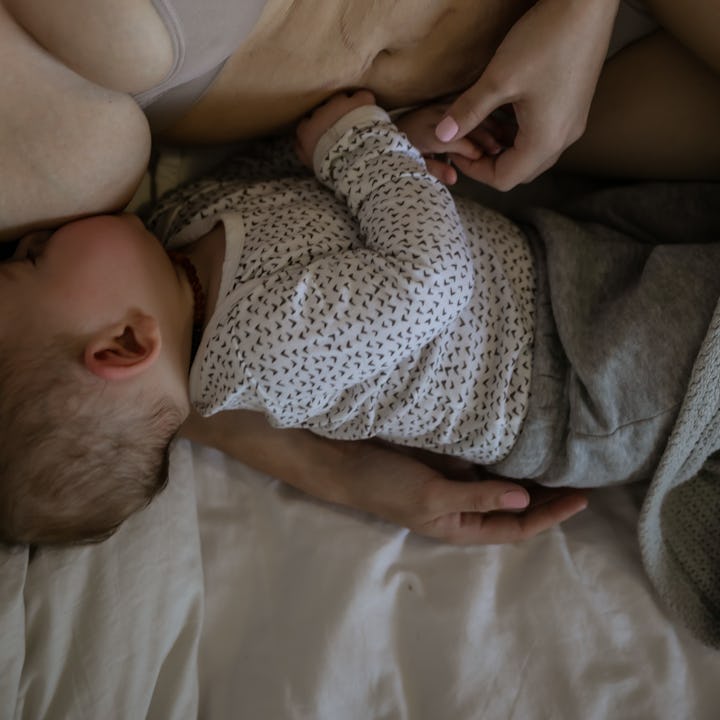 A moment in the postpartum life of a mother at home with her baby boy and toddler girl, she is tired...