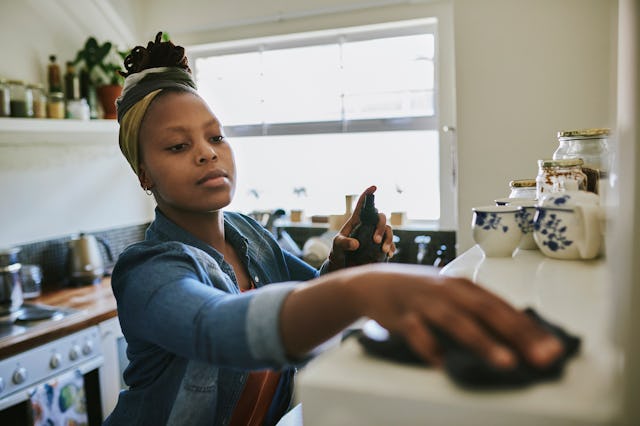 Cropped shot of a young woman cleaning the kitchen at home